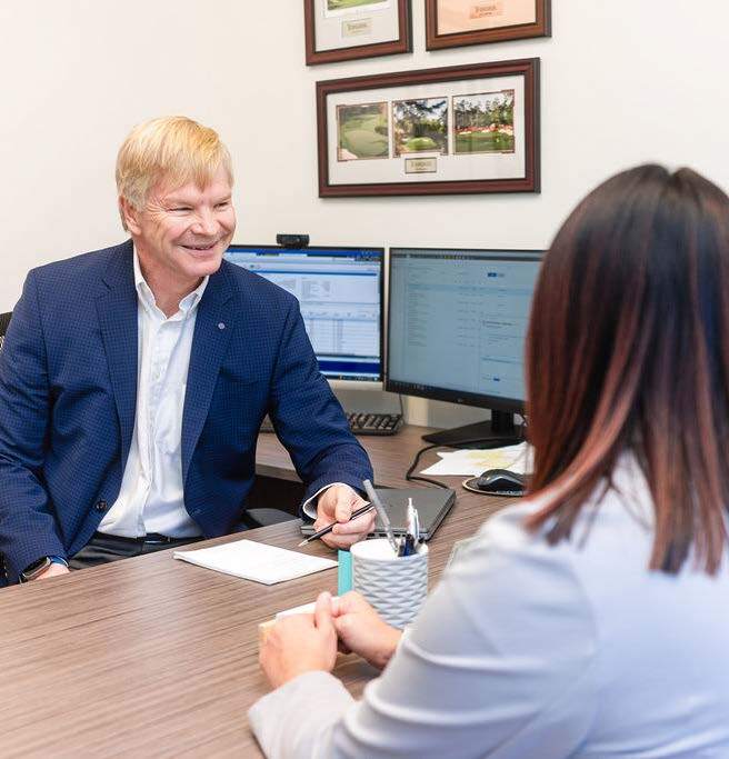 Ron talking with a client at his desk